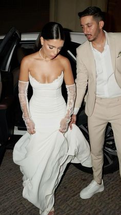 the bride and groom are getting out of their car together, dressed in beige suits