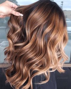 a woman is getting her hair done by another person with long brown and blonde hair