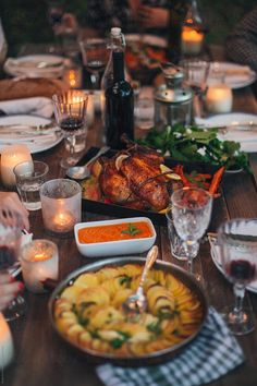 a dinner table is set with food and candles