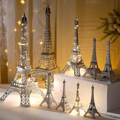 the miniature eiffel tower is lit up with fairy lights and sits on a table