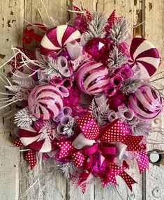 a pink and silver christmas wreath on a door