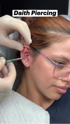 a woman is getting her ear pierced by an electric hair dryer with the caption that reads, daith piercing