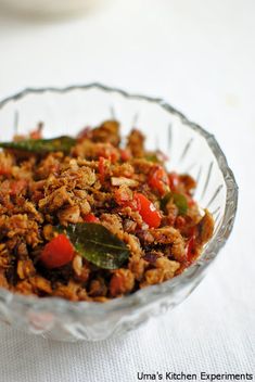 a glass bowl filled with food sitting on top of a white tablecloth covered table