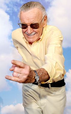 an older man wearing sunglasses is smiling and stretching his arms out in the air with one hand