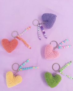 four crocheted heart keychains with beaded beads and charms on them