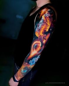 a man with a tattoo on his arm is looking at the sky and has an orange fire