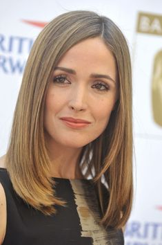 a woman with long brown hair wearing a black and white dress