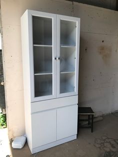 a tall white cabinet sitting next to a wall