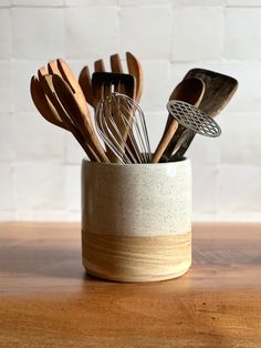 wooden utensils in a ceramic cup on a table