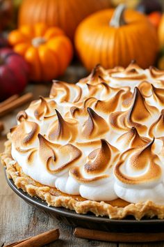 a pie with meringue and whipped cream on top sitting on a wooden table