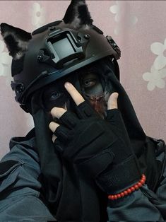 a person wearing a dog mask and holding their hand up to his face with both hands