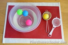 three balls in a bowl and two spoons on a red place mat