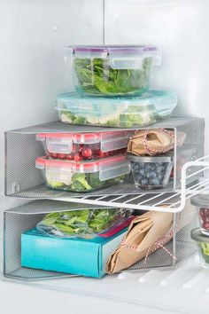 the refrigerator door is open and there are many containers on it, including lettuce