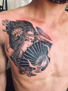 a man with a tattoo on his chest holding a fan