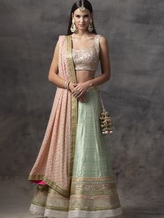 This mint green raw silk lehenga with multi-borders is paired with a peach choli blouse embellished with tila and sequence work.  The outfit is completed with a georgette mukaish work dupatta. Lengha Dress, Mehendi Dress, Peach Dupatta, Green Dress Outfit, Green Lehenga Choli, Peach Color Dress, Mukaish Work, Lehenga Bridesmaid, Sequence Blouse