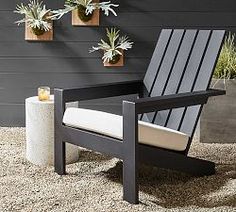 a chair sitting on top of a gravel covered ground next to potted planters