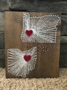 two string art pieces with red heart on them