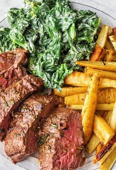 steak, french fries and spinach on a plate