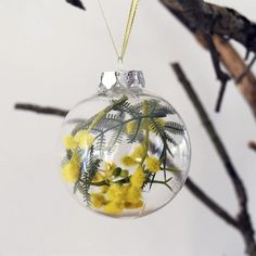 a glass ornament with yellow flowers in it