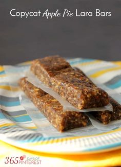 two pieces of apple pie lara bars on a blue and yellow plate with the title copycat apple pie lara bars