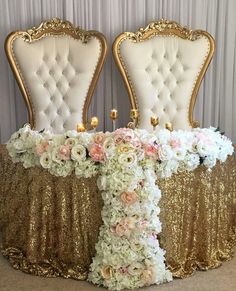 two gold chairs with white and pink flowers on them