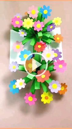 an origami flower arrangement on top of a piece of paper with the video below it