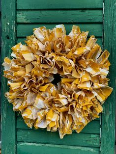 a green door with a yellow wreath hanging on it