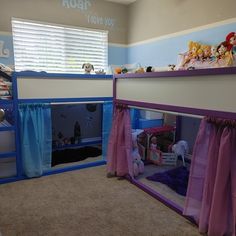 a room with two bunk beds and curtains on the windowsills is decorated in purple and blue