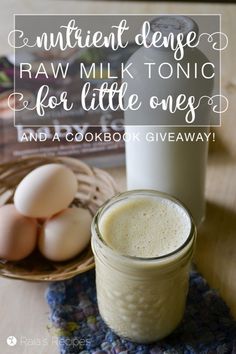 a glass jar filled with milk next to some eggs on a plate and a book