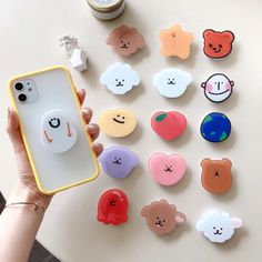 a person holding a cell phone case with many different shaped buttons on the back of it