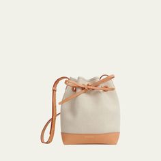 Mansur Gavriel bucket bag in canvas linen and cotton  Adjustable crossbody strap, 24.5"L Self-tie drawstring closure  Approx. 9.8"H x 7"W x 4.8"D Made in Italy Canvas Bucket Bag With Canvas Lining, Beige Canvas Bucket Bag With Canvas Lining, Canvas Crossbody Bucket Bag With Leather Trim, White Canvas Crossbody Bucket Bag, Modern Canvas Crossbody Bucket Bag, Cream Canvas Bucket Bag With Adjustable Strap, Chic Canvas Crossbody Bucket Bag, Beige Canvas Bucket Bag With Detachable Strap, Modern Canvas Bucket Bag With Detachable Strap