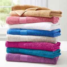 towels stacked on top of each other in front of a window