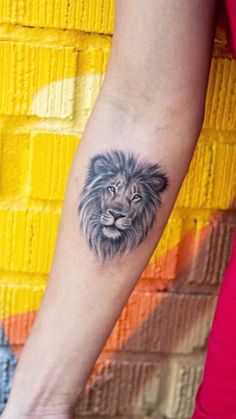 a woman's arm with a lion tattoo on it