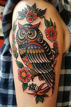 an owl with flowers and leaves on it's thigh