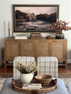 a living room filled with furniture and a painting on the wall above it's coffee table