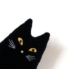 a crocheted black cat hat with yellow eyes