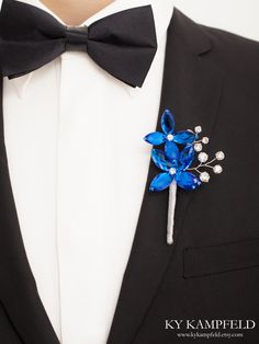 a man in a tuxedo with a blue flower on it's lapel