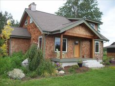 a brown house sitting on top of a lush green field