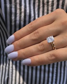 a woman's hand with a ring on it and a diamond in the middle