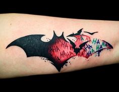 a batman tattoo with the words happy halloween written on it and two bats in different colors