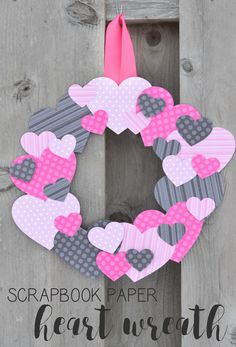 a paper heart wreath hanging on the side of a wooden door with text overlay that says scrapbook paper heart wreath