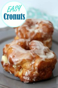 two glazed donuts sitting on top of a gray plate with the words easy cronuts