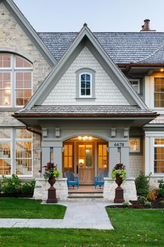 a large house with two blue chairs in the front yard and windows on each side