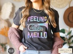 It's marching band season! This Feeling Mello shirt will quickly become a wardrobe favorite of any mellophone player. We print on premium Bella and Canvas brand softstyle shirts for the ultimate comfort and softness. More marching band shirts available at my homepage https://www.etsy.com/shop/AbbyZachDesigns ----HOW OUR SHIRTS ARE MADE ----  * We use the process of DTG, which stands for direct to garment printing. We partner with a professional printer who applies ink directly into the shirt. (W Marching Band Mom, Marching Band Shirts, Band Mom Shirts, Saxophone Player, Mama Tshirts, Band Mom, Jazz Band, Mama Tee, Band Shirts