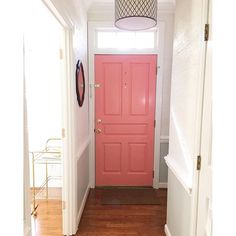 a bright pink door is in the hallway