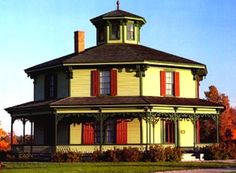 a large yellow house with red shutters on the windows