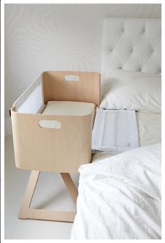 a bed with white sheets and a wooden box on it