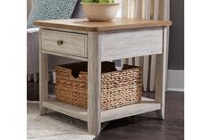 a white table with two baskets under it and a vase on the end table next to it