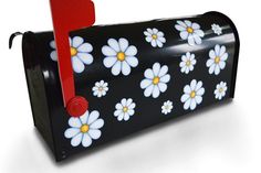 a black mailbox with white flowers painted on it