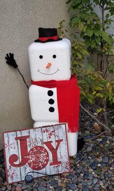 a snowman with a joy sign next to it